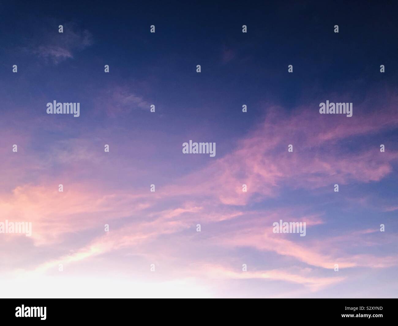 Pink clouds at sunset in a wide blue sky - Smartphone Captured Stock Image