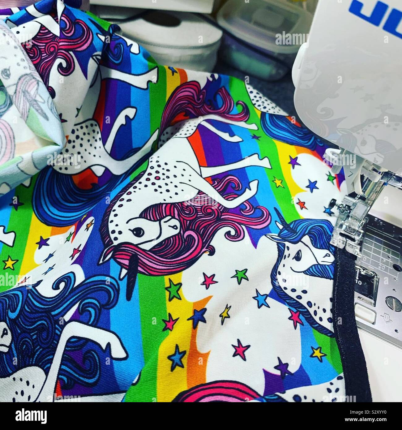 Sewing rainbow unicorn fabric - Smartphone Captured Stock Image