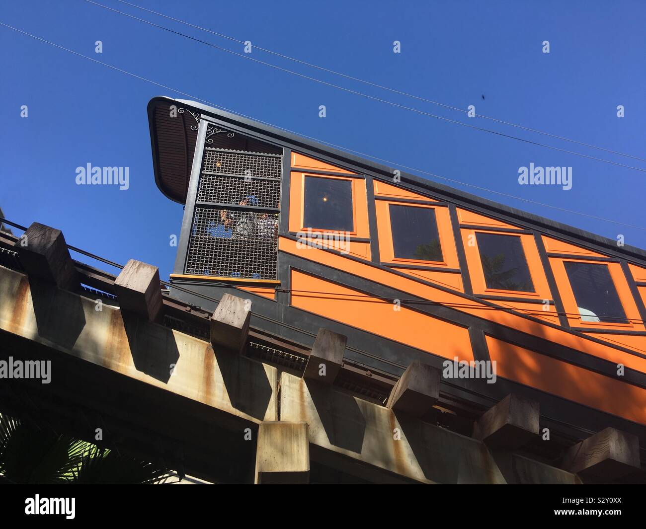 LOS ANGELES, CA, AUG 2019: blue sky with bright orange Angels Flight funicular railway car passing in Bunker Hill area of Downtown - Smartphone Captured Stock Image