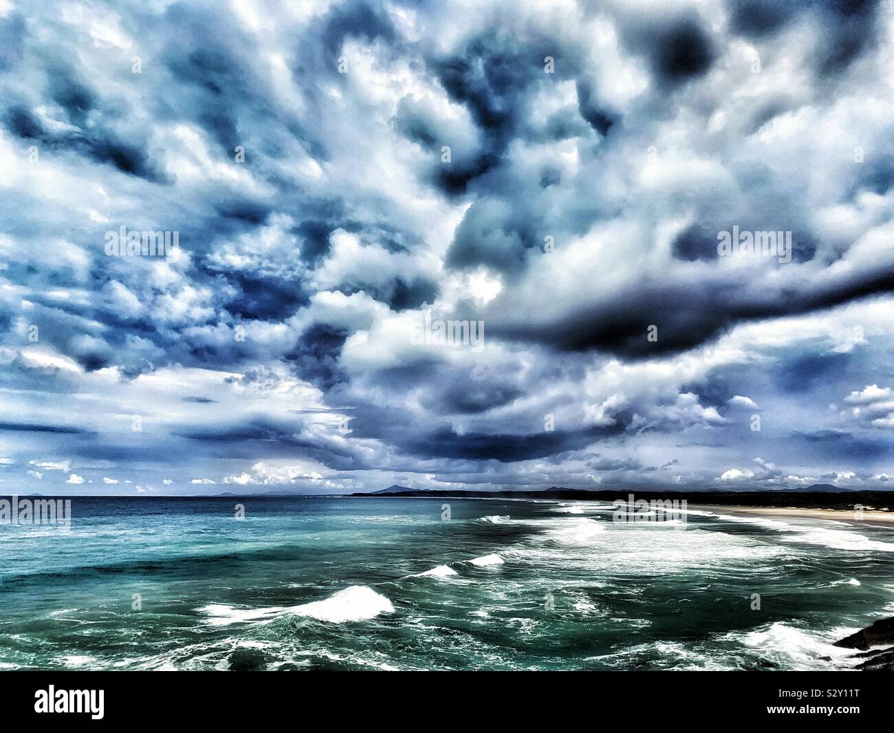 Dramatic Ocean beach and storm clouds with added drama - Smartphone Captured Stock Image