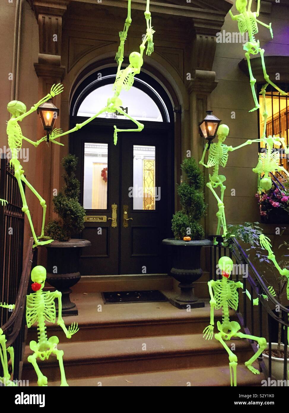 Halloween skeletons on the front of a brownstone in midtown Manhattan, NYC, United States - Smartphone Captured Stock Image