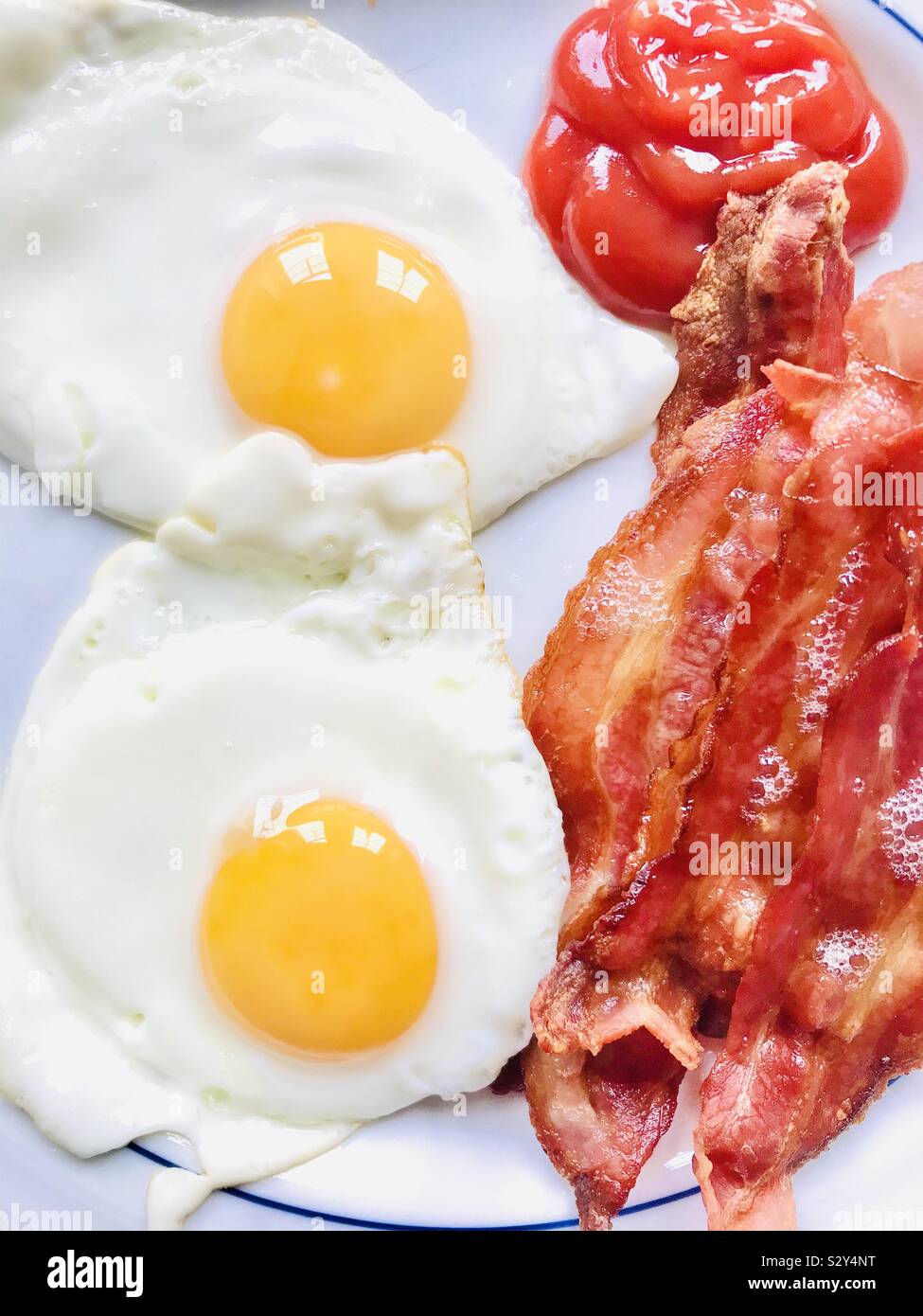 Bacon and fried eggs with tomato ketchup Stock Photo Alamy