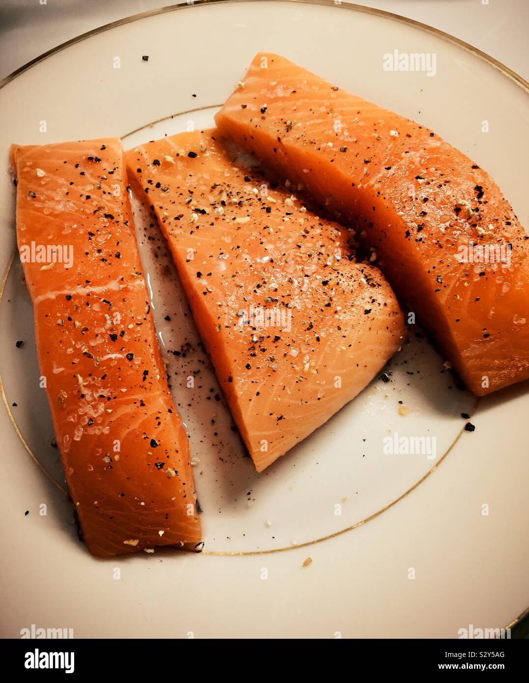 Still life of three raw fresh salmon fillets on a plate , seasoned and ready to cook, USA - Smartphone Captured Stock Image