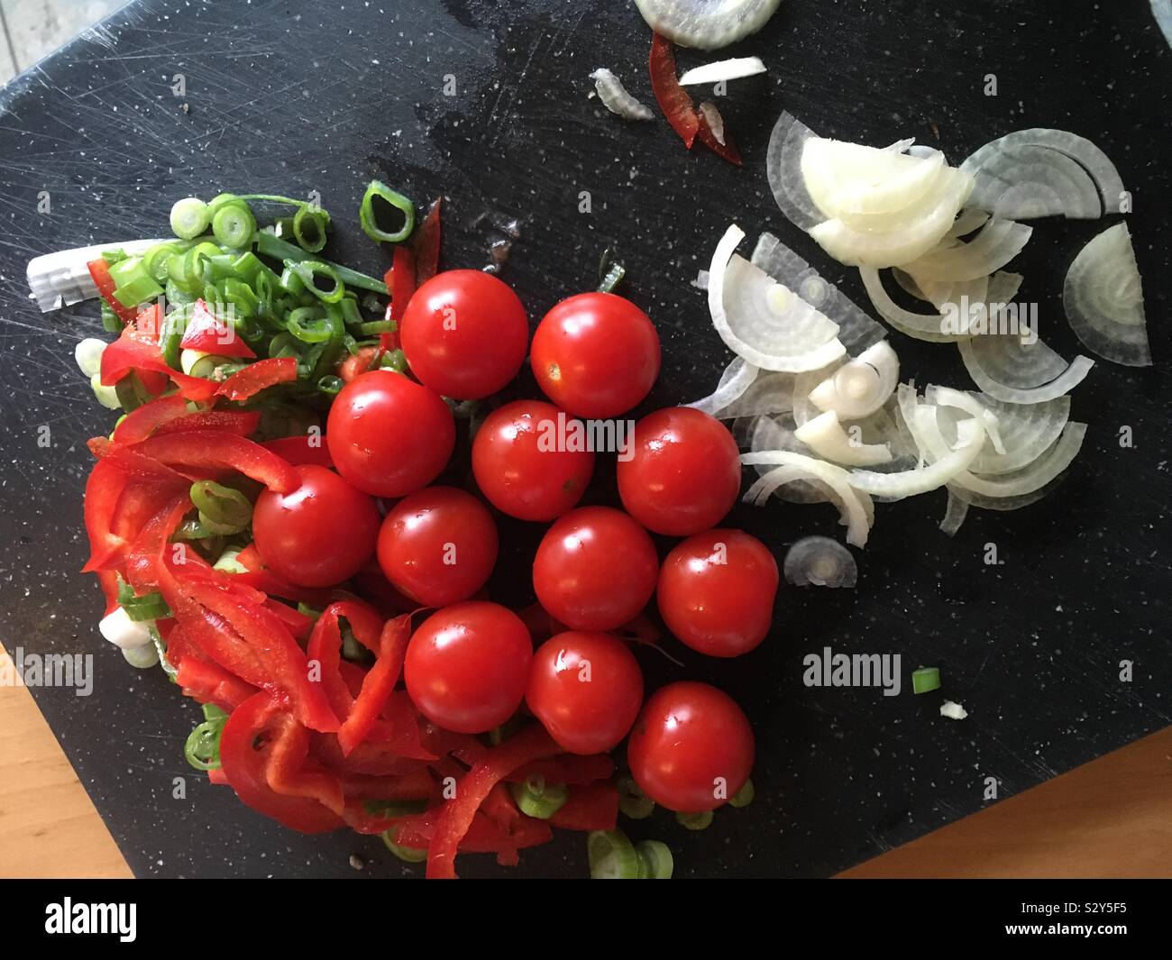 Kirsch Tomaten, Zwiebel, Paprika und Frühlingszwiebel vorbereitet und geschnitten für die Zubereitung Stock Photo
