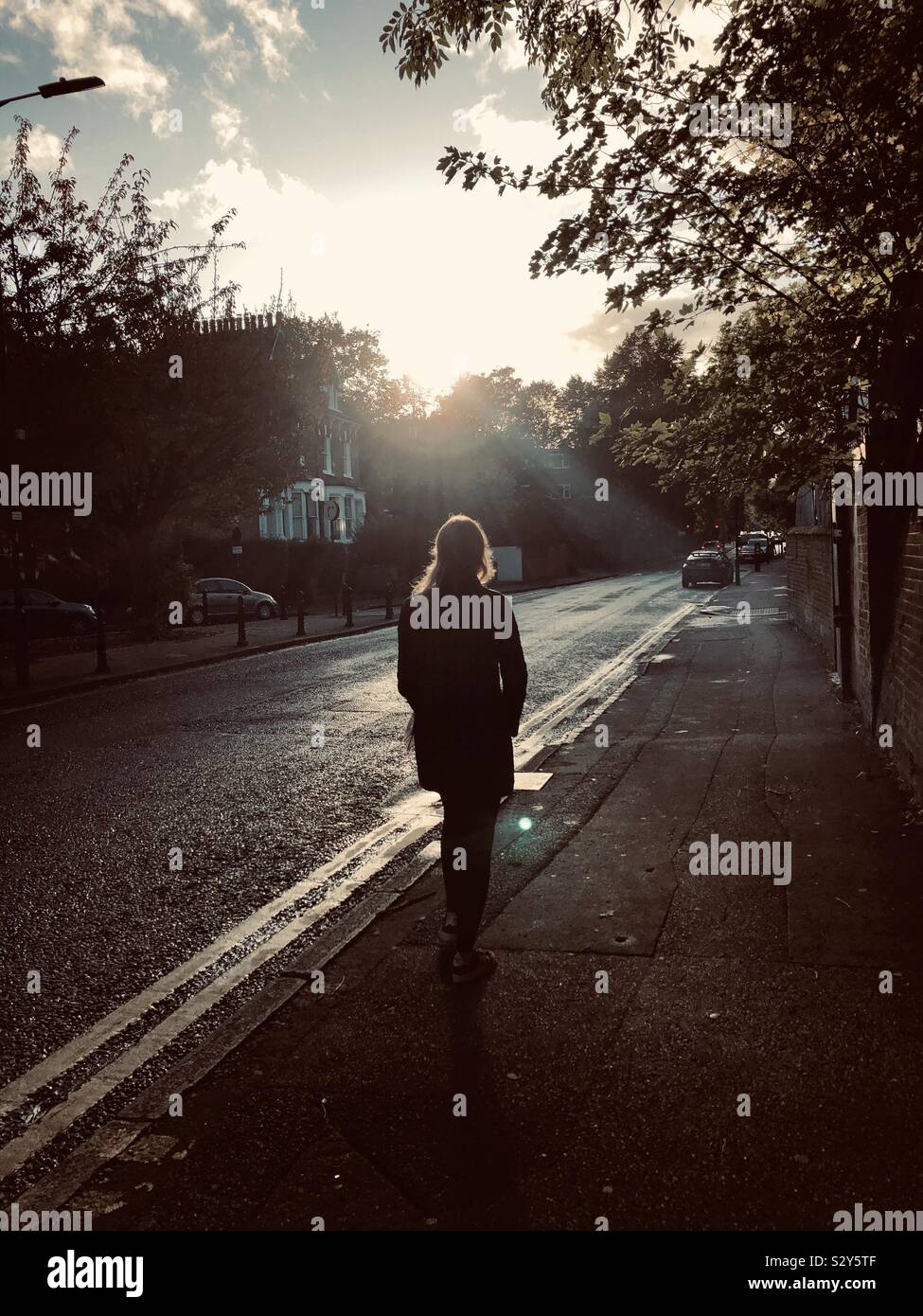 A woman is walking during sunset in London - Smartphone Captured Stock Image