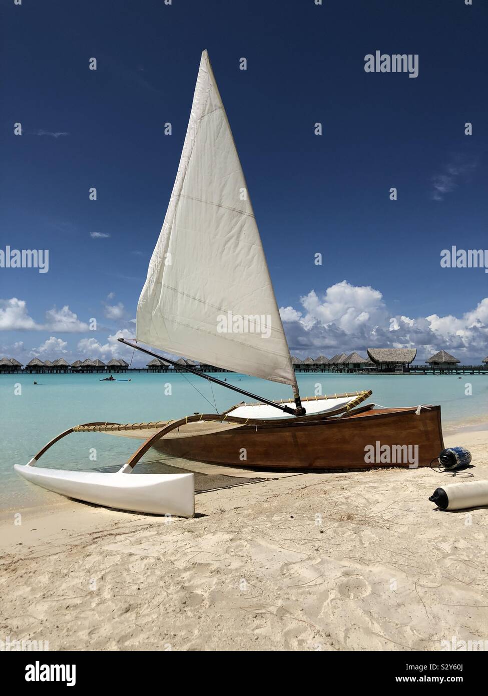 Sailing boat in the turquoise sea and exotic sandy beach on Bora Bora paradise island. French Polynesia. Stock Photo