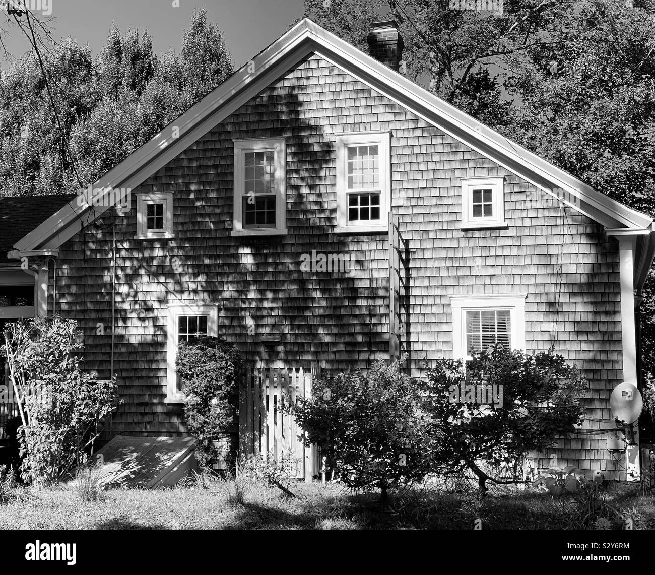 Black and white image of a shingled house in sunlight and shadow, Wellfleet, Cape Cod, Massachusetts, United States - Smartphone Captured Stock Image