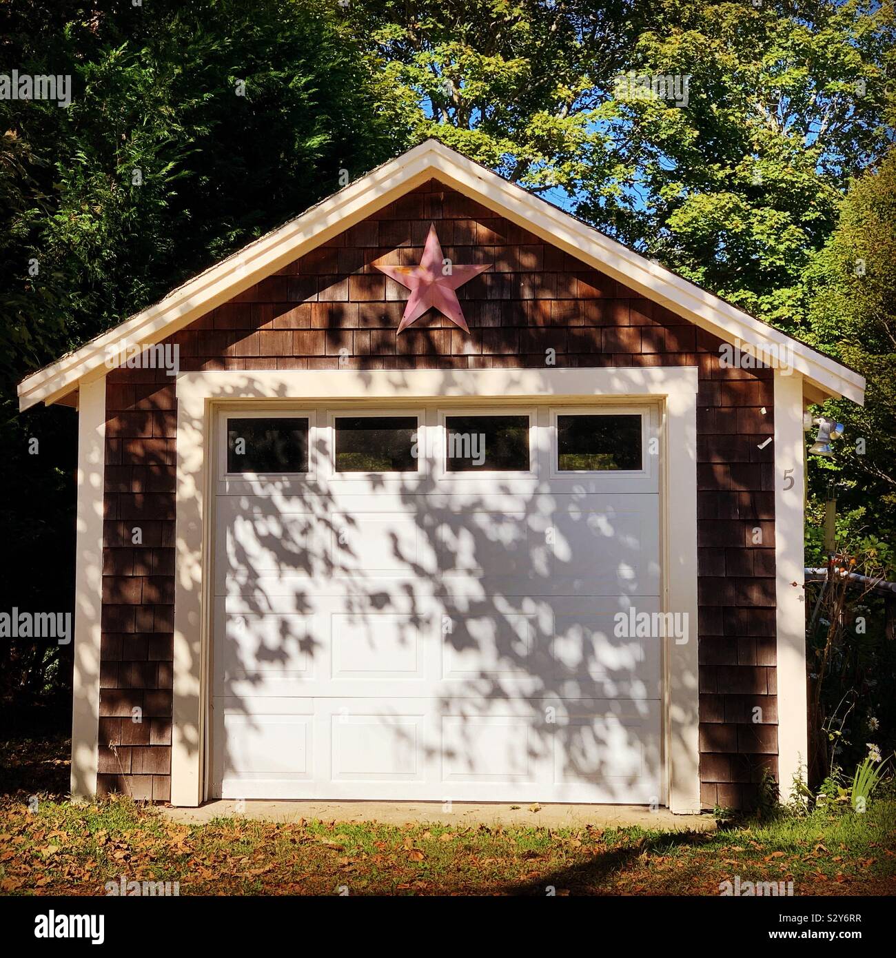 Dappled sunlight on a garage in Wellfleet, Cape Cod, Massachusetts, United States - Smartphone Captured Stock Image