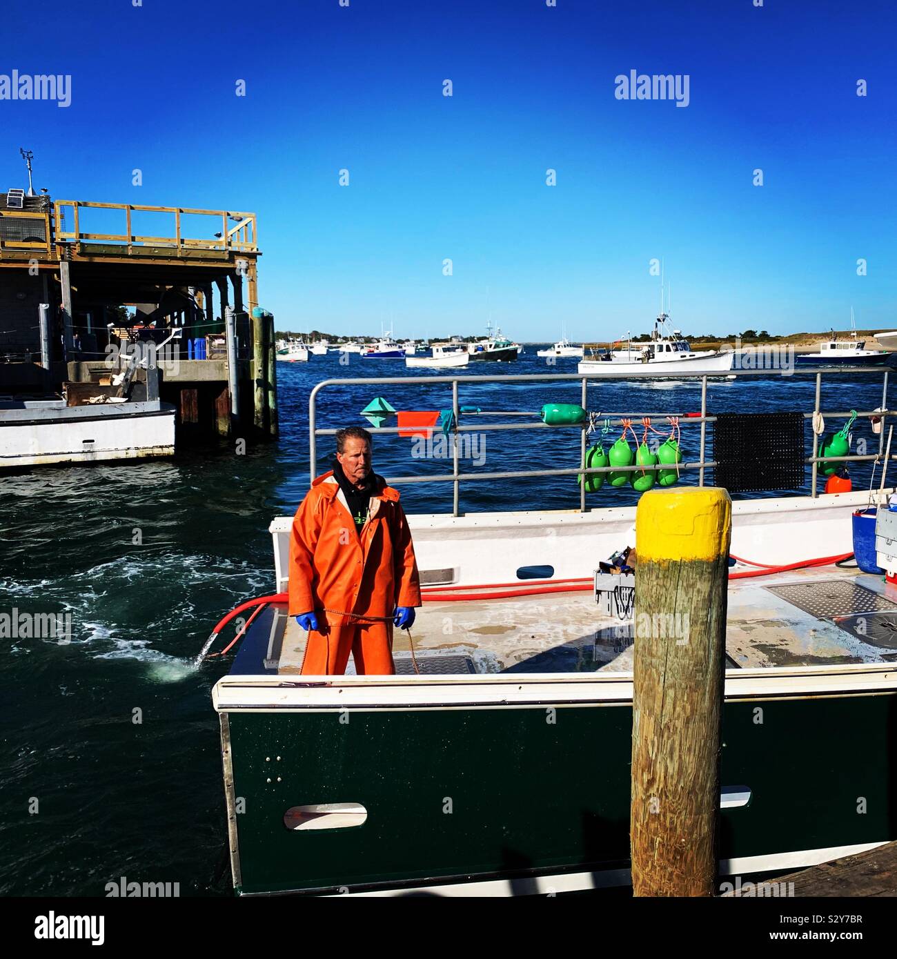 Fisherman on a boat at Chatham Pier, Chatham, Cape Cod, Massachusetts, United States - Smartphone Captured Stock Image