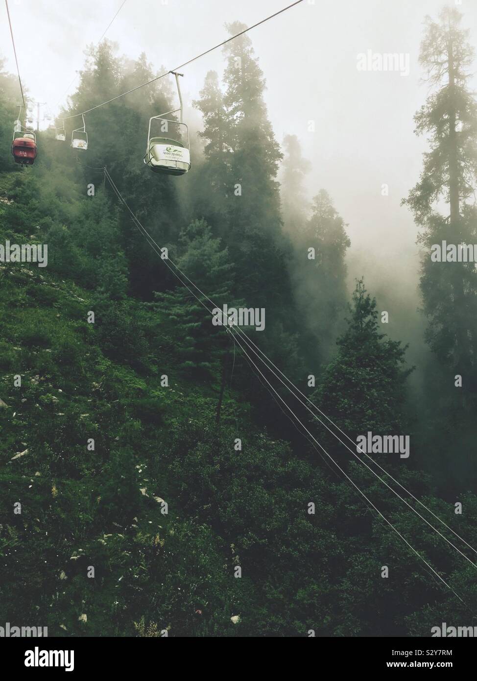 Cable car near Murree, Punjab, Pakistan. There is fog and a lot of greenery. Stock Photo