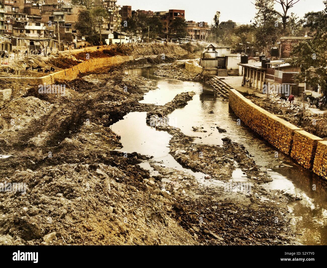 Muddy river bed in Kathmandu where they choose to fix the walls in monsoon season. Stock Photo