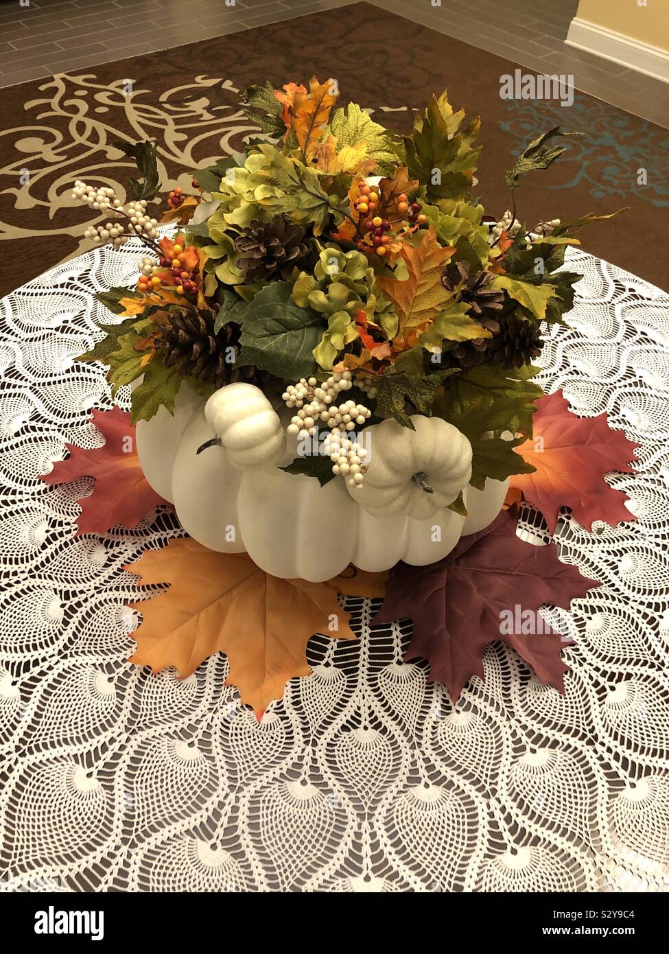 Beautiful autumn centerpiece on a table with a lace tablecloth Stock