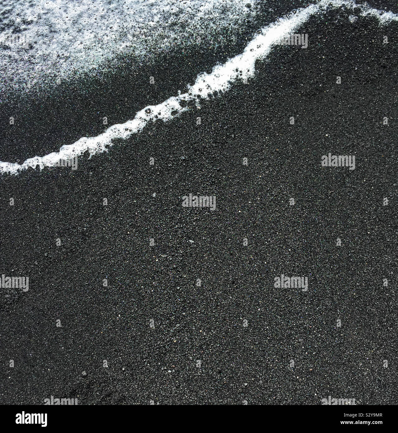 Black sand beach and surf in the big island of Hawaii - Smartphone Captured Stock Image