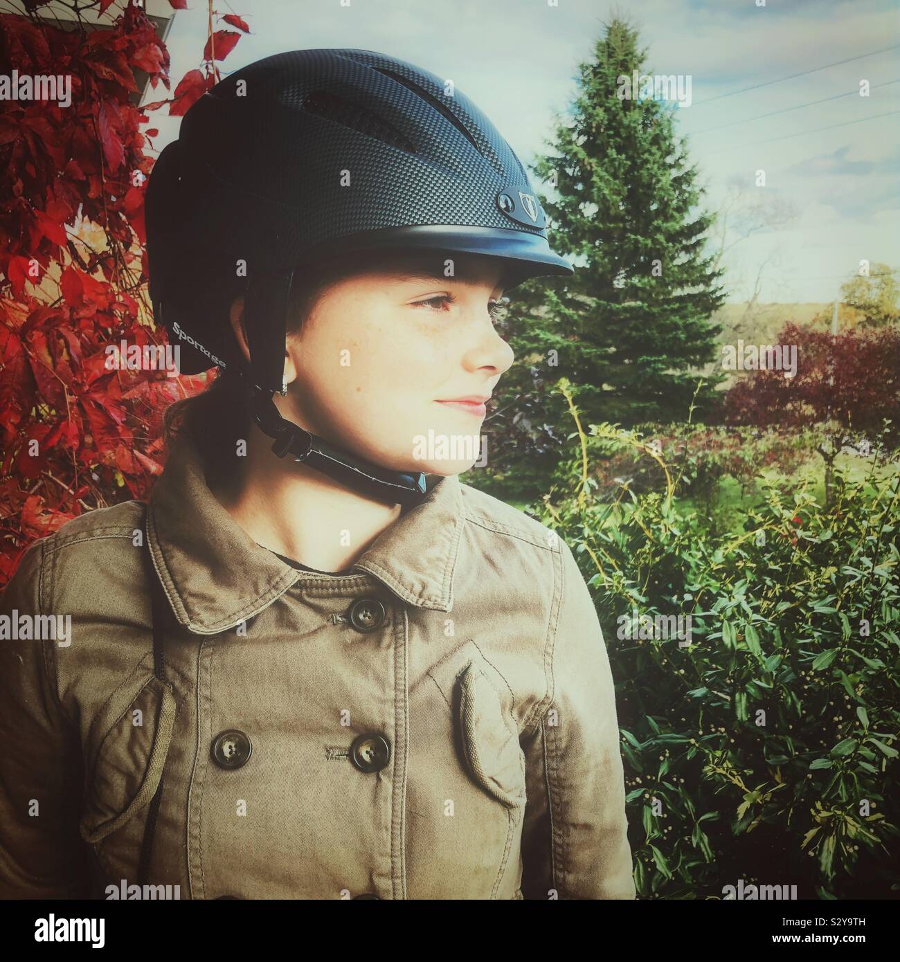 Girl wearing riding helmet looking to the side - Smartphone Captured Stock Image
