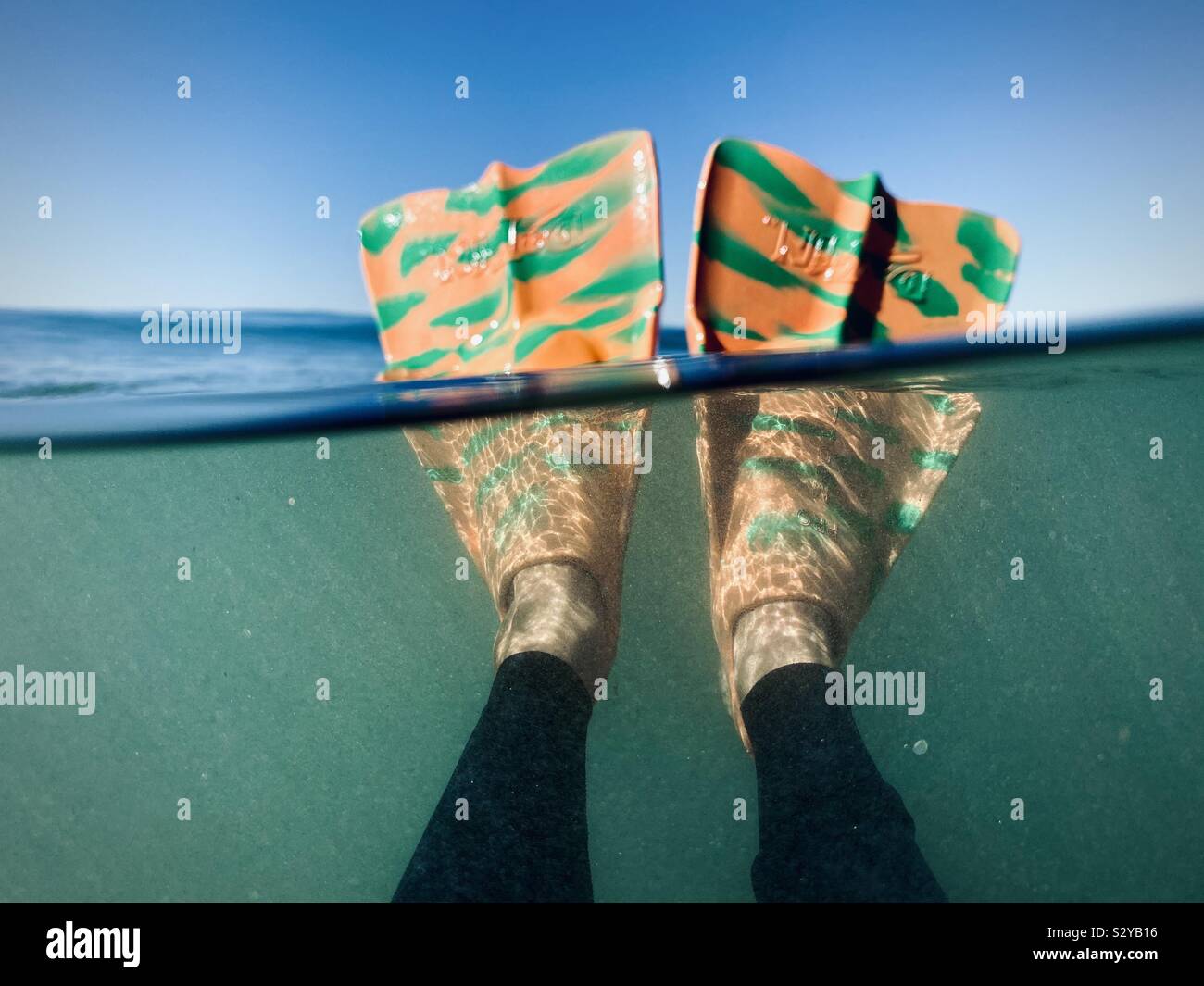 Over underwater photo of a male wearing swim fins in the ocean. Manhattan Beach, California, USA. - Smartphone Captured Stock Image