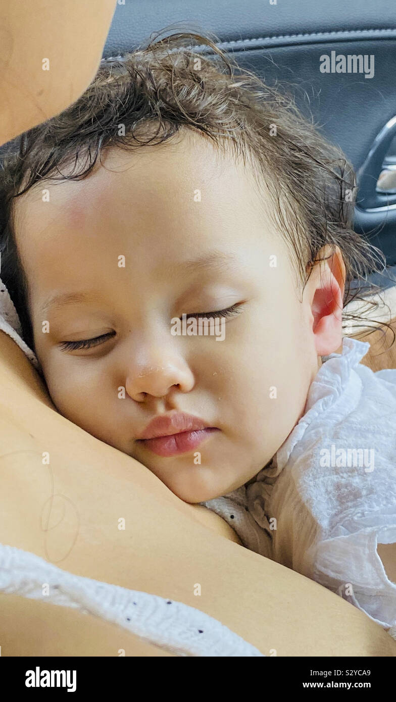 Baby sleeps in mothers arms - Smartphone Captured Stock Image