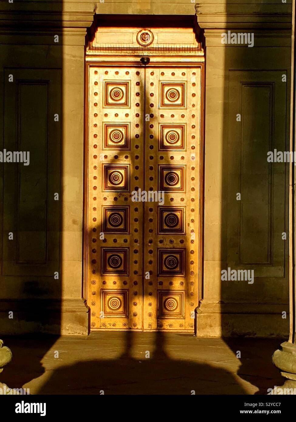 The shadow of Glasgow’s famous Duke of Wellington with his Cone hat on the doors of the Gallery of Modern Ar at Sunrise during the Equinox - Smartphone Captured Stock Image