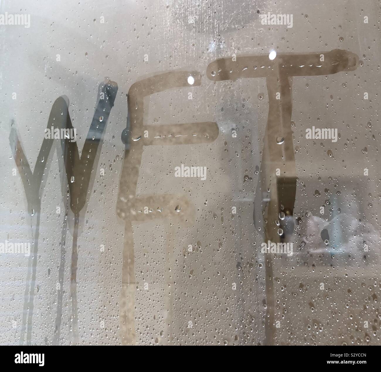 The word WET written in condensation on a shower screen Stock Photo