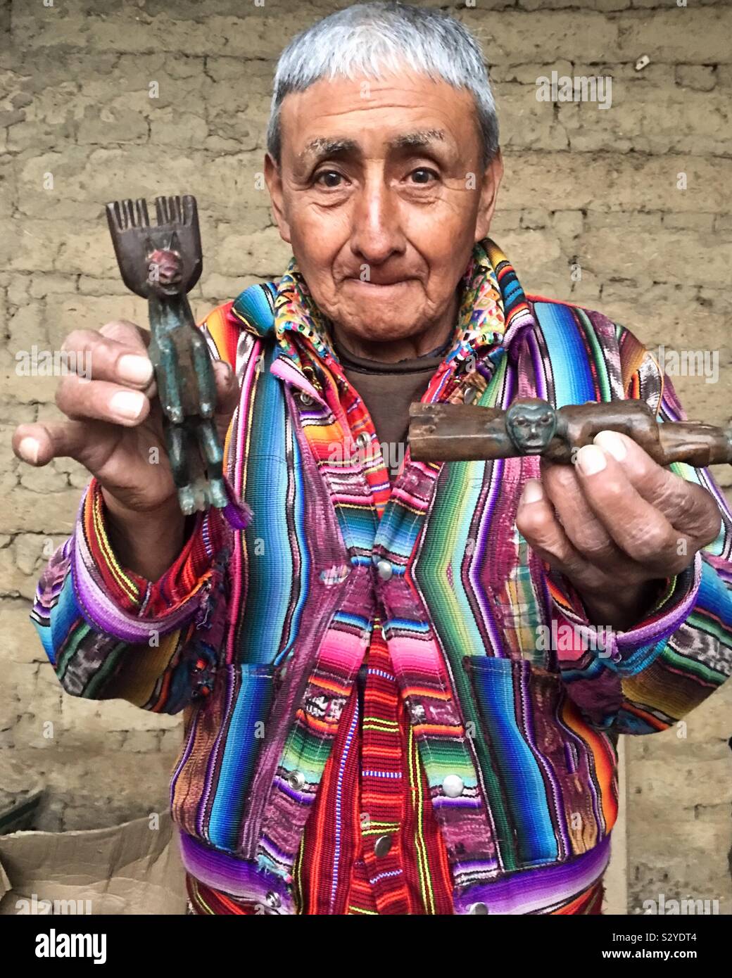 Guatemalan folk artist Antonio showing his hand carved slingshots Stock Photo
