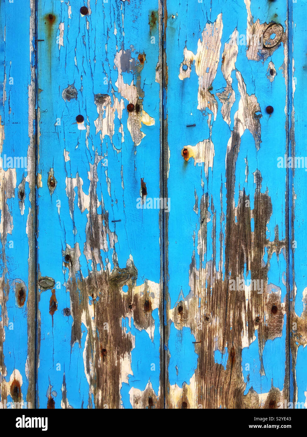 Old wooden door with peeling blue paint - Smartphone Captured Stock Image