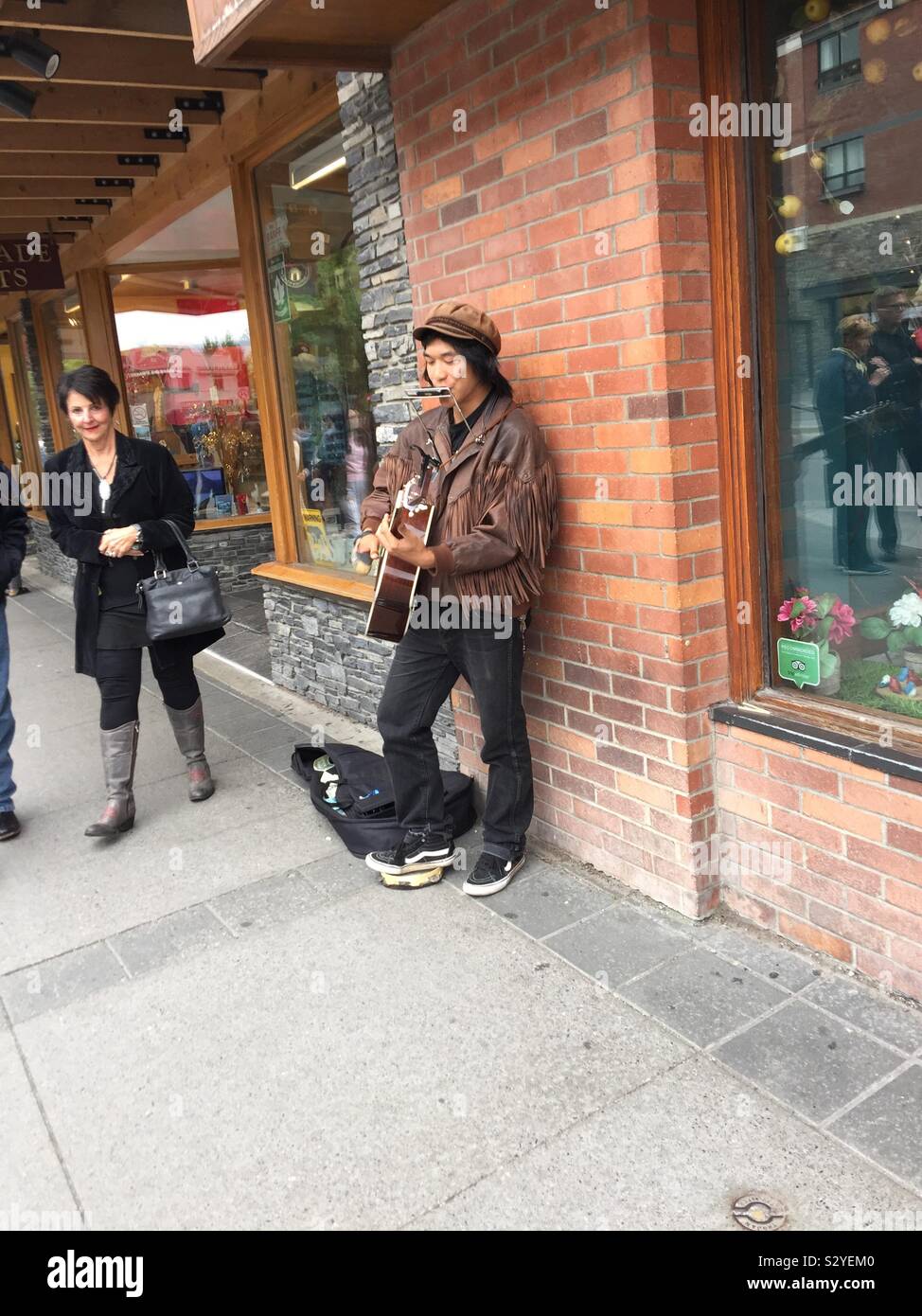 Visit town of Banff, Alberta, Canada, Banff National Park,street photography, Street musician, busker, guitar, harmonica - Smartphone Captured Stock Image