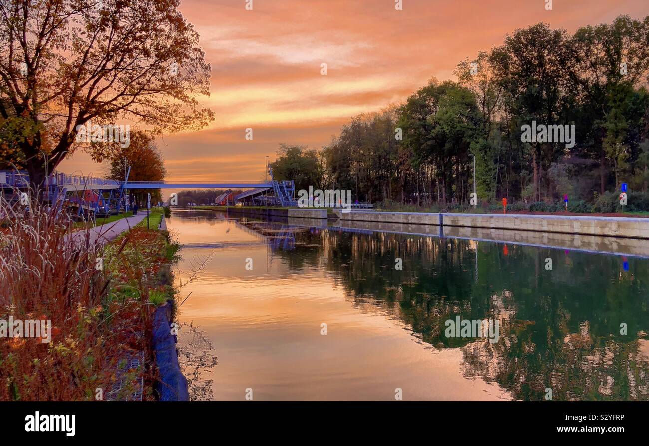 Orange colored sunrise sky reflected in the water of a river in a fall Countryside landscape - Smartphone Captured Stock Image