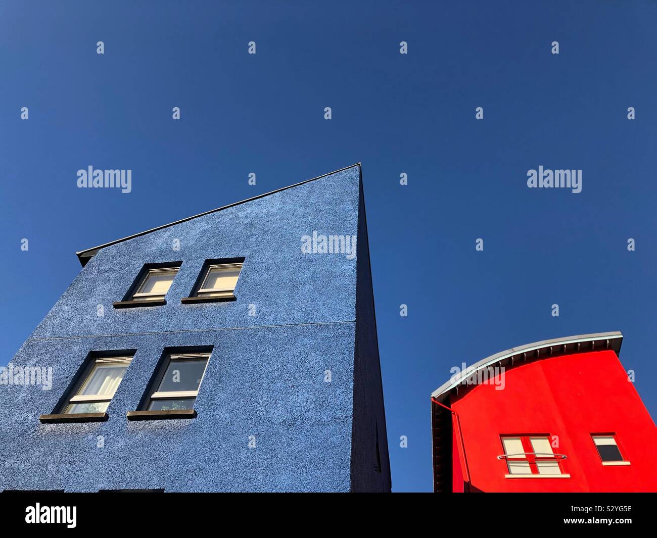 Red and blue building against a blue sky - Smartphone Captured Stock Image