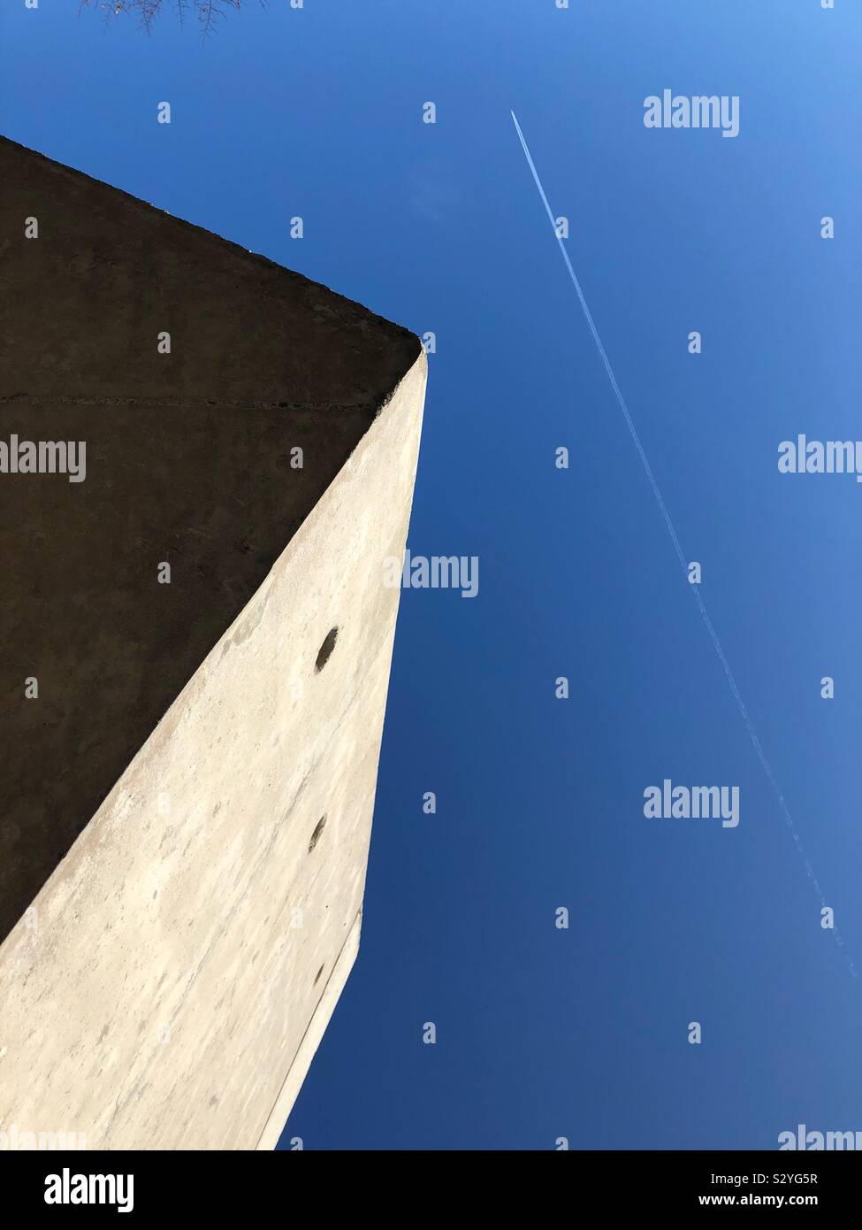 Looking up at aeroplane from an urban building - Smartphone Captured Stock Image