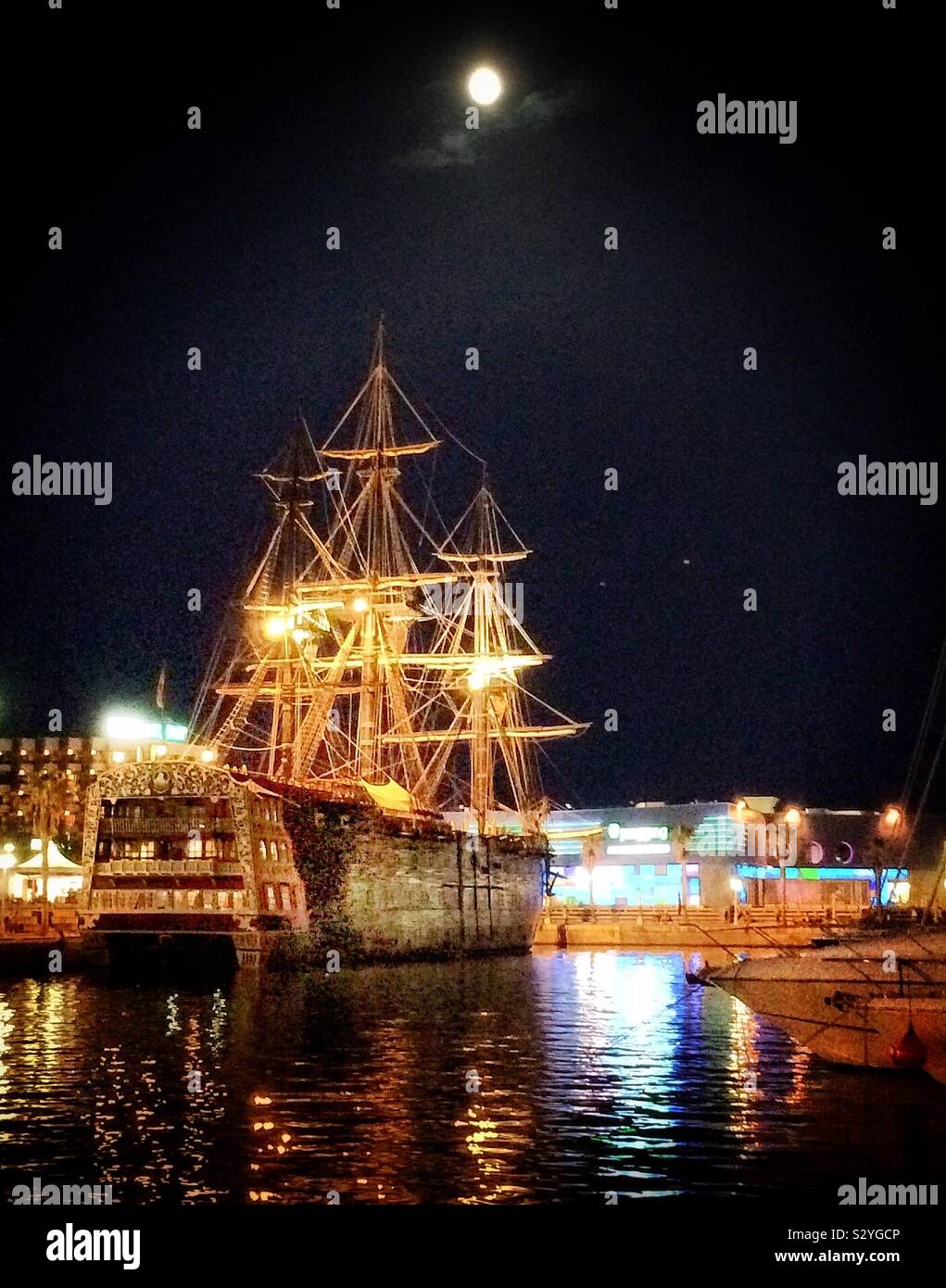A full moon over the port of Alicante, Spain where a magnificent galleon is harboured - Smartphone Captured Stock Image