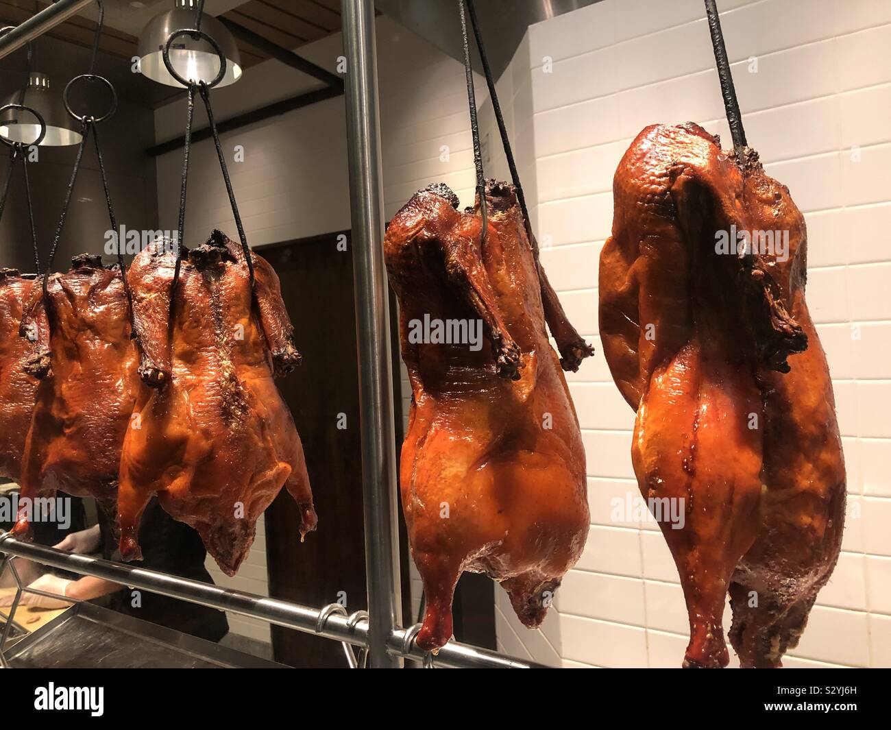 Roasted Peking duck hanging in restaurant window, Miami, Florida, USA