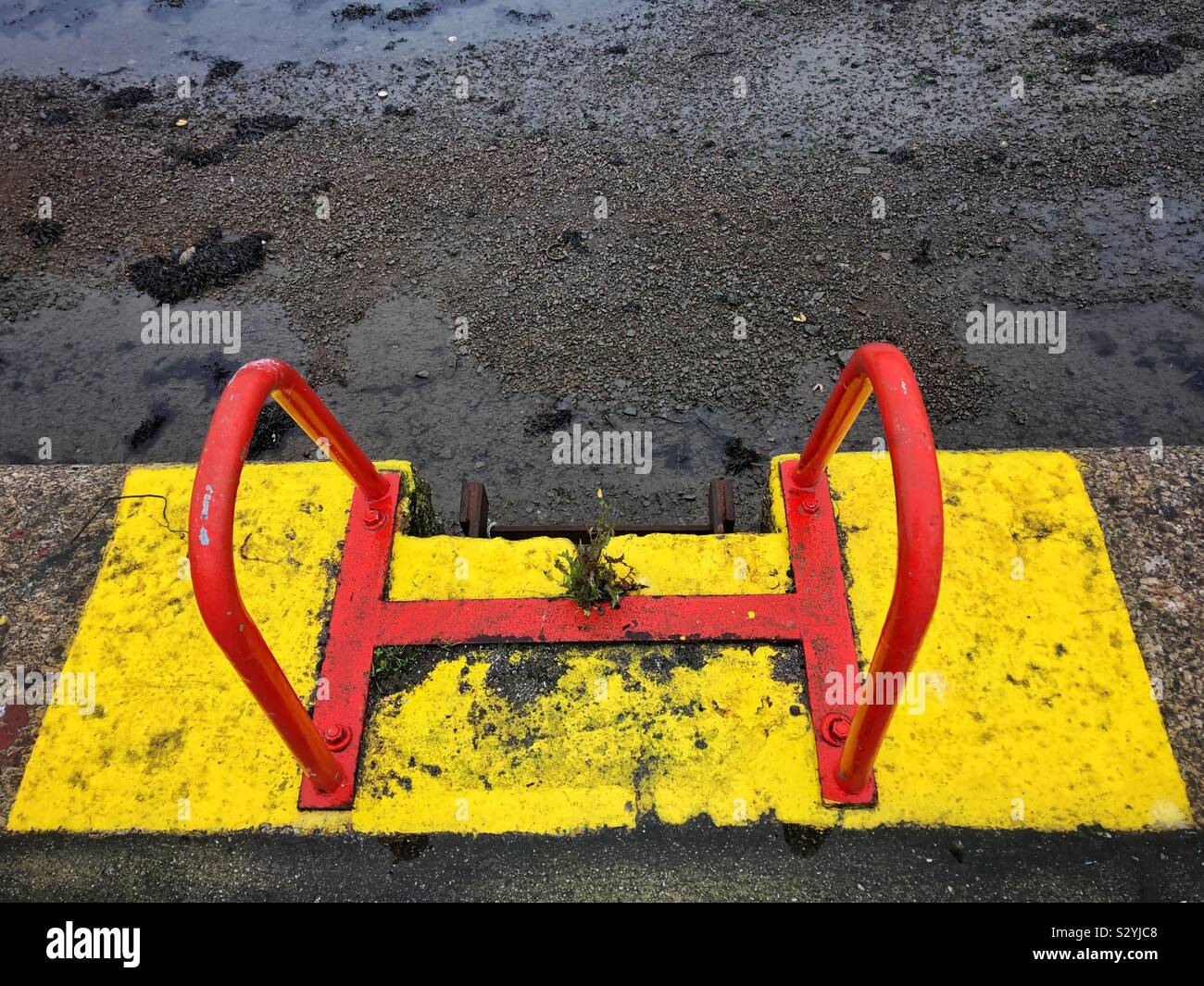 Red steps on a yellow background on a harbour side wall. - Smartphone Captured Stock Image