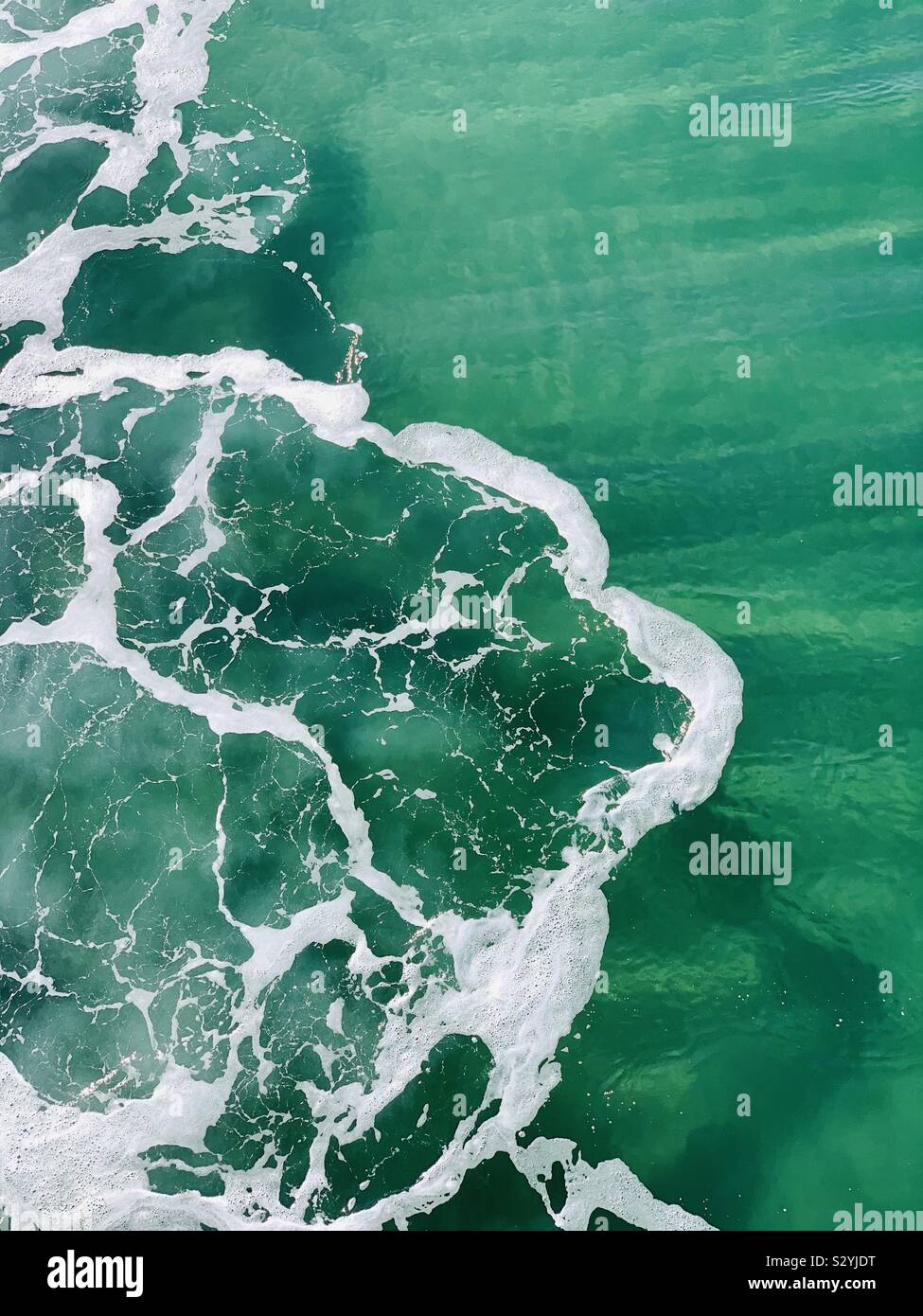 Wave foam making patterns in the ocean. Manhattan Beach, California USA. - Smartphone Captured Stock Image