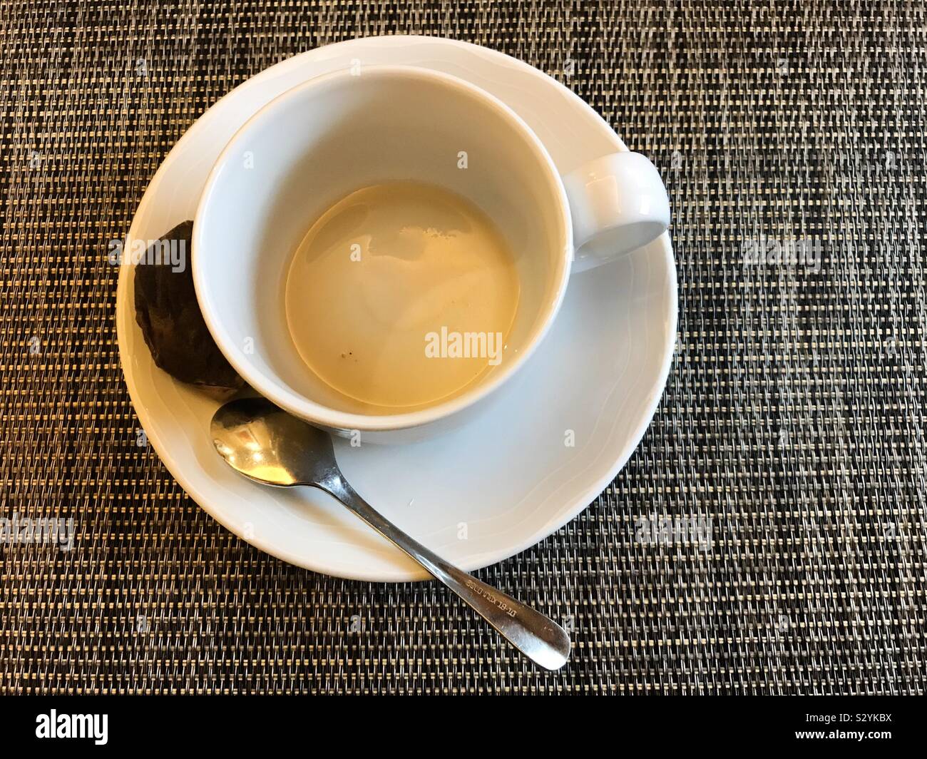 Empty tea cup and saucer with used teabag and teaspoon. - Smartphone Captured Stock Image