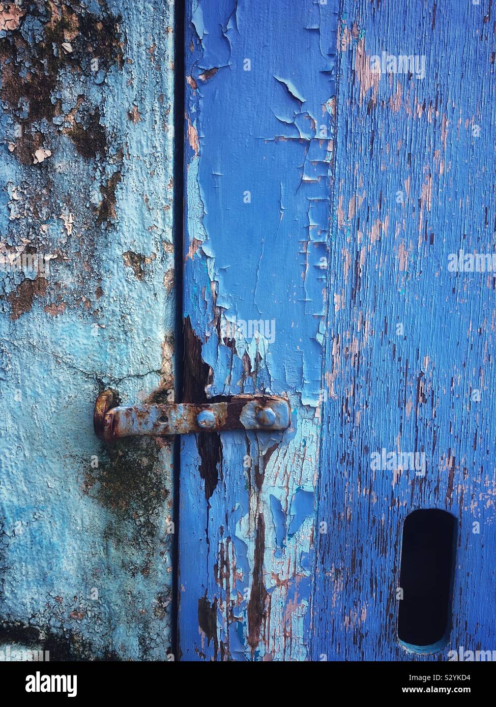 Old blue door with peeling blue paint Stock Photo