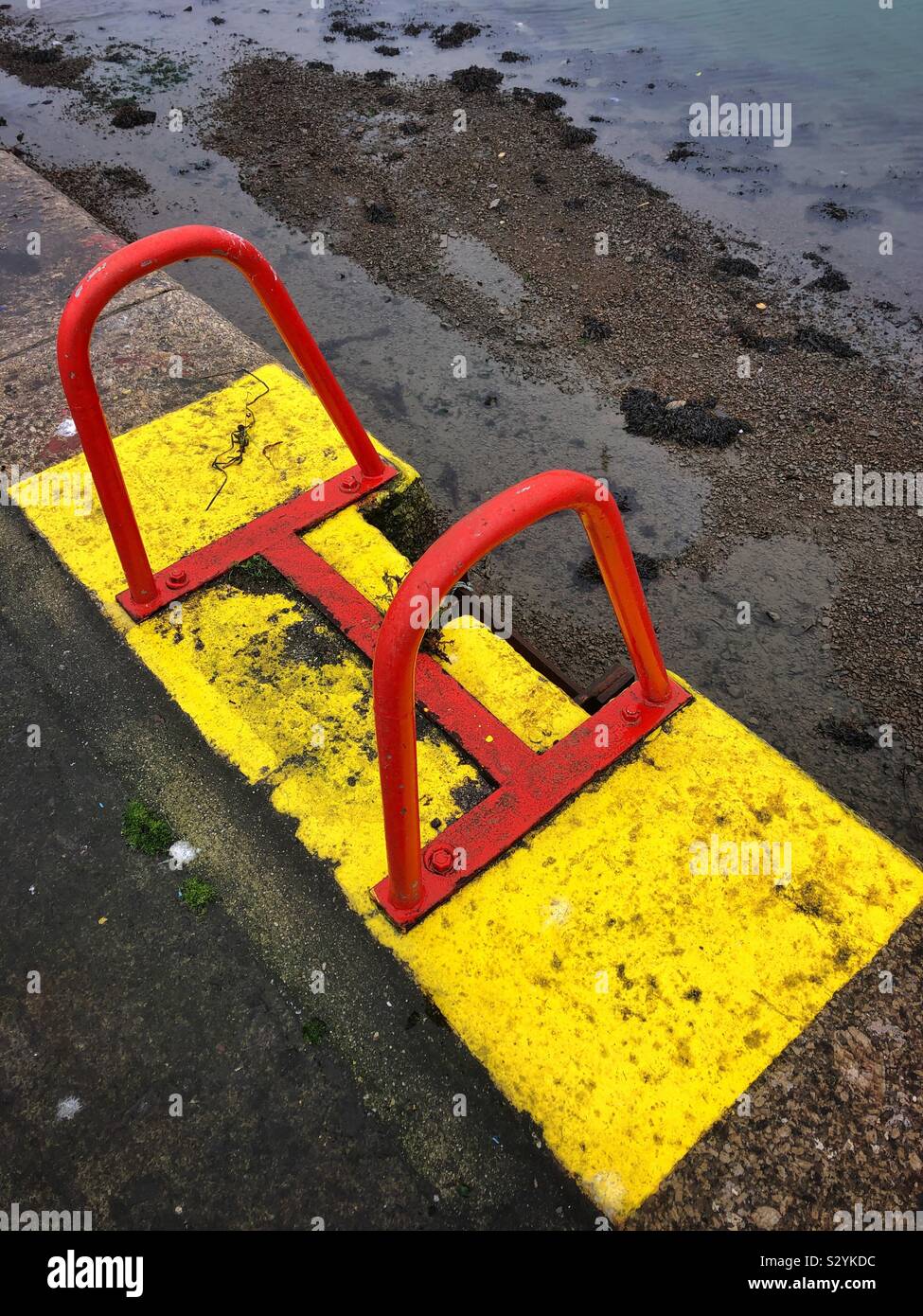 Yellow and red steps on a harbour wall, Cornwall. - Smartphone Captured Stock Image