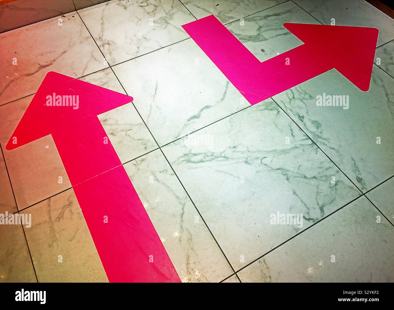 Arrows on a tile floor pointing in different directions Stock Photo Alamy