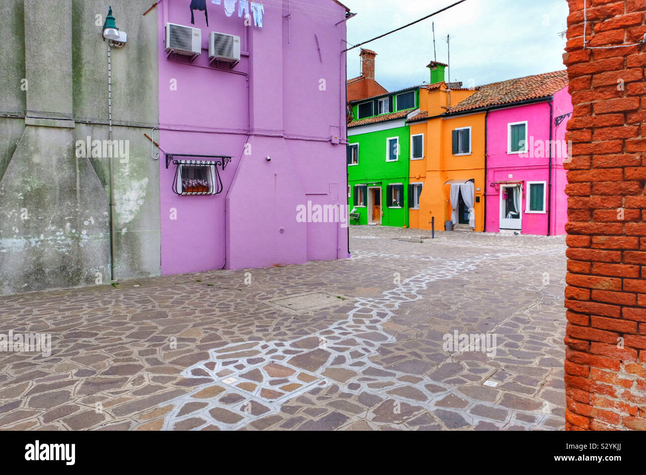 Street with brightly coloured houses and paved path - Smartphone Captured Stock Image