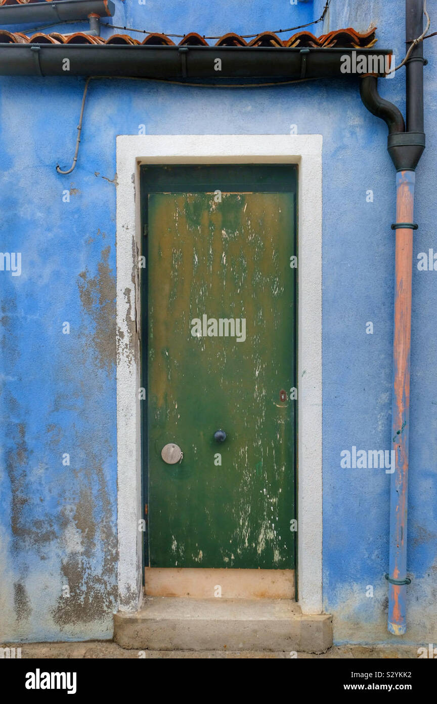A door and doorway in need of restoration with a drainpipe - Smartphone Captured Stock Image