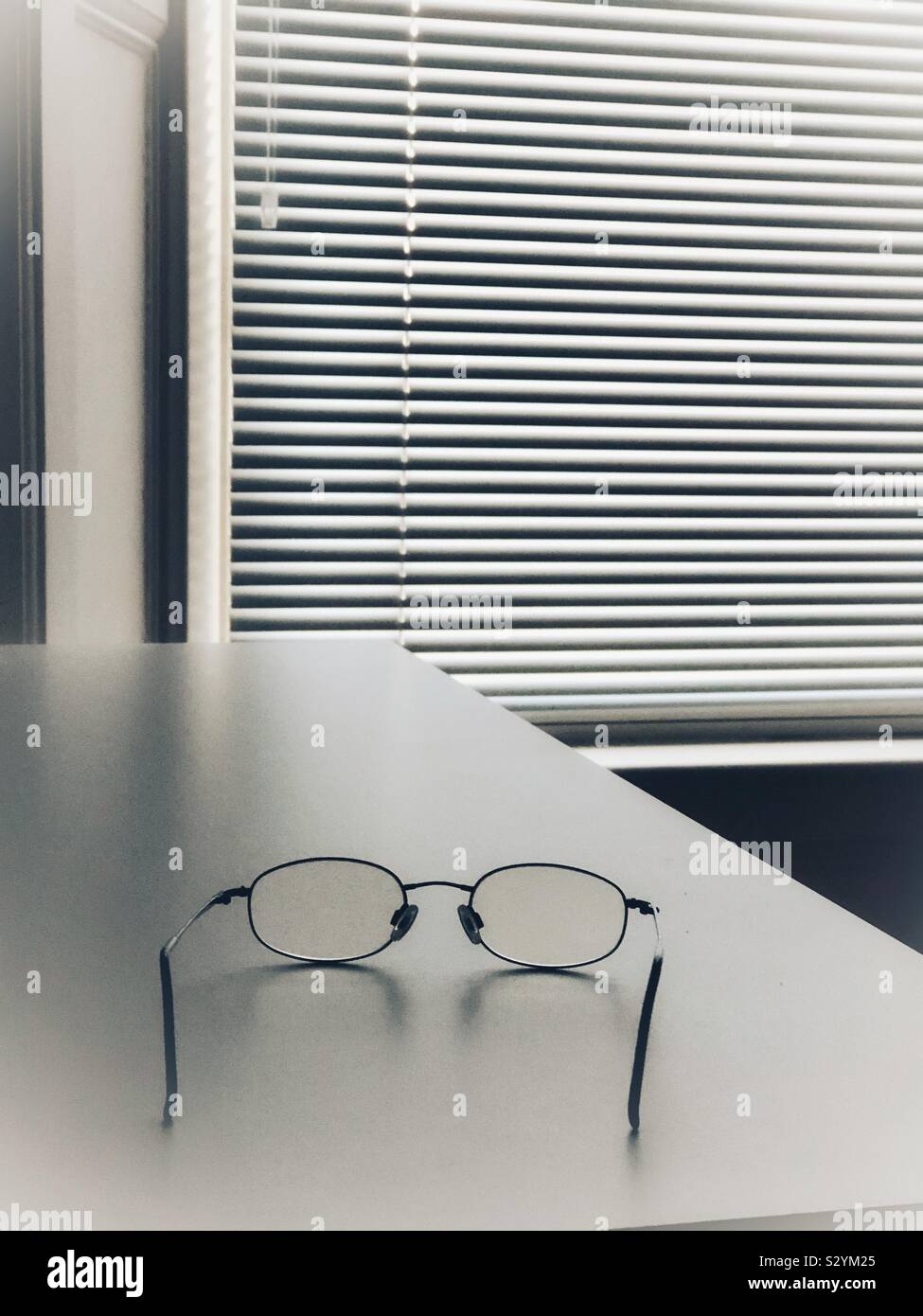 Spectacles on bedside table Stock Photo