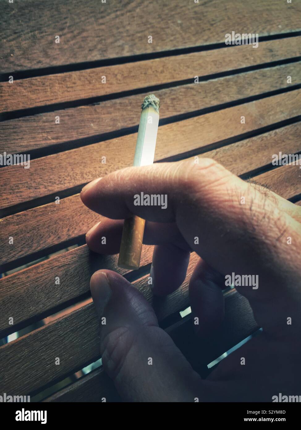 Close up man’s hand holding a cigarette Stock Photo