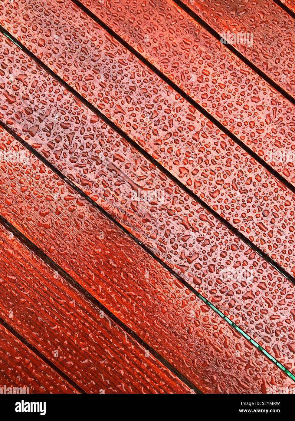 Outdoor Wooden table covered in raindrops - Smartphone Captured Stock Image