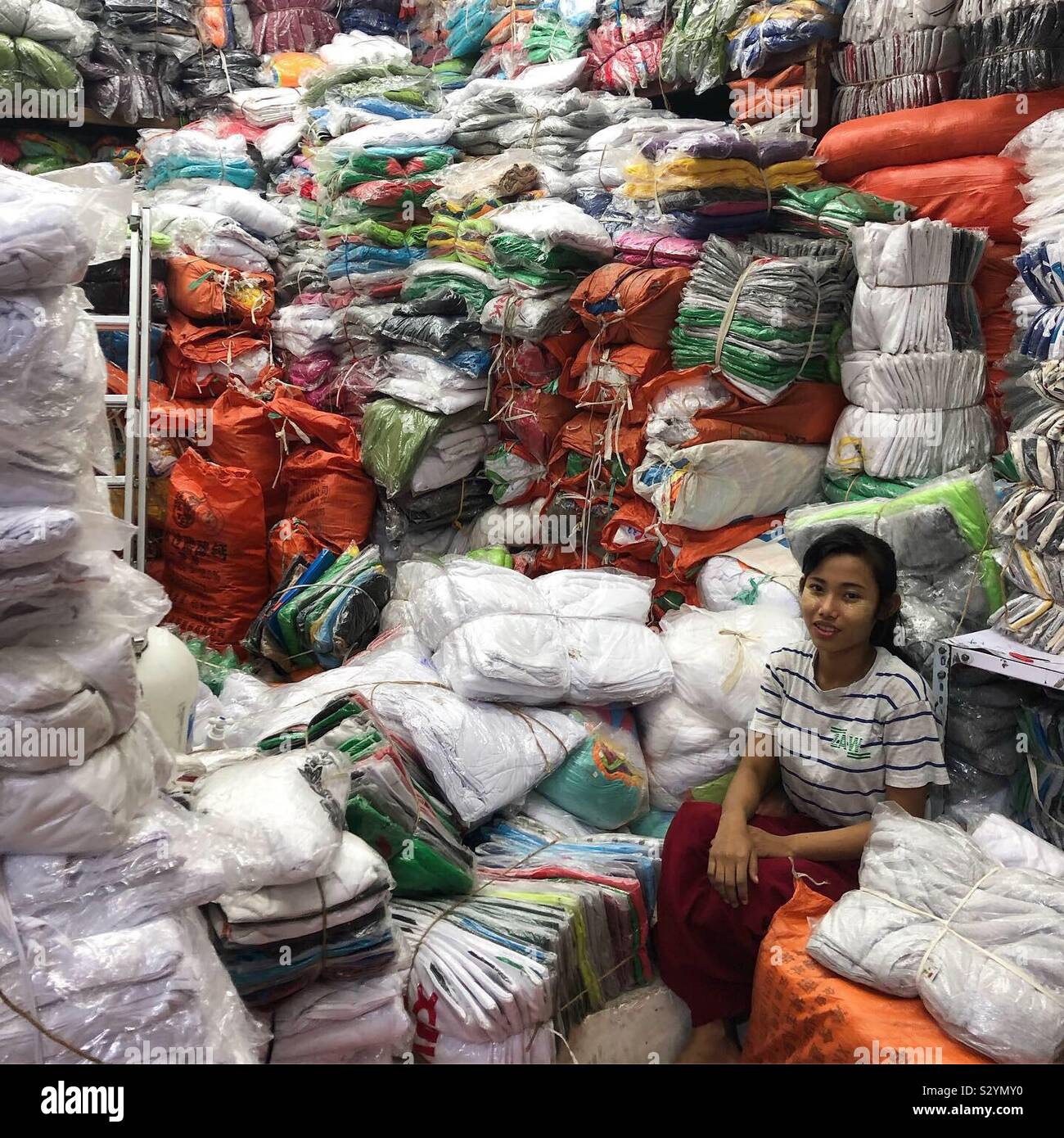 A young woman sits in her stall at Mandalay’s largest local market. - Smartphone Captured Stock Image