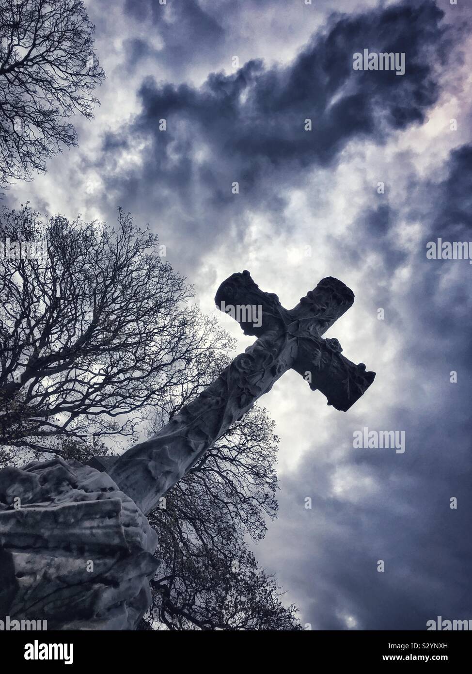Gravestone cross against a dramatic sky - Smartphone Captured Stock Image