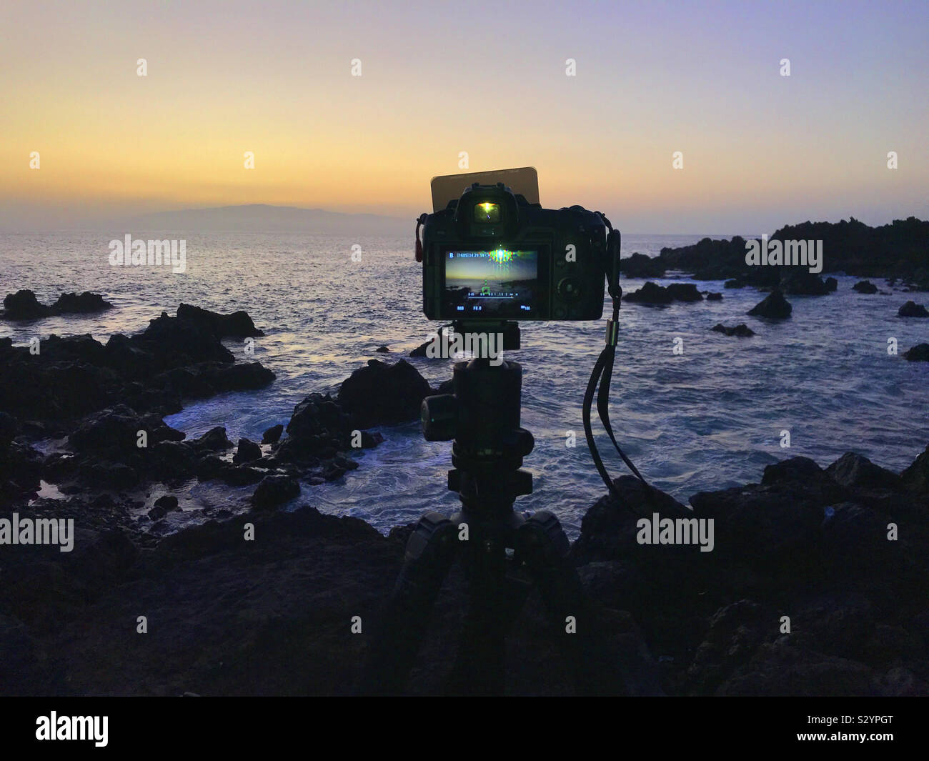 Canon EOS R with filters making a seascape photo on the rocky west coast of Tenerife at sunset Stock Photo