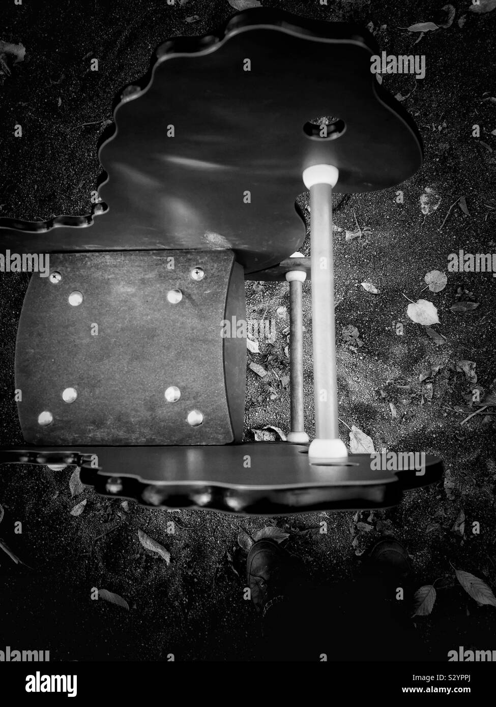 Elevated view of black and white image of hobby horse in children’s playground in autumn - Smartphone Captured Stock Image