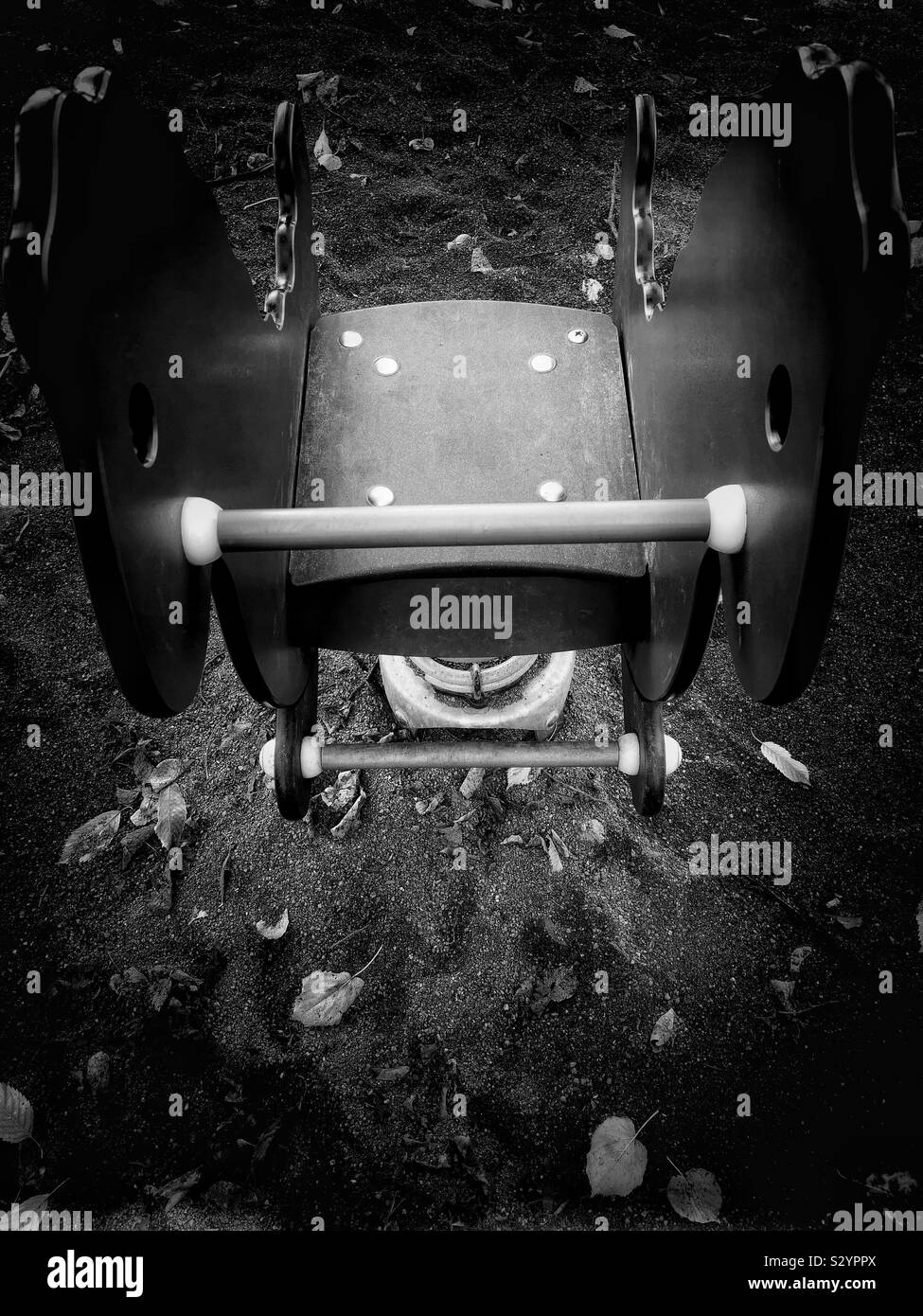 Elevated black and white image of playground hobby horse in autumn - Smartphone Captured Stock Image