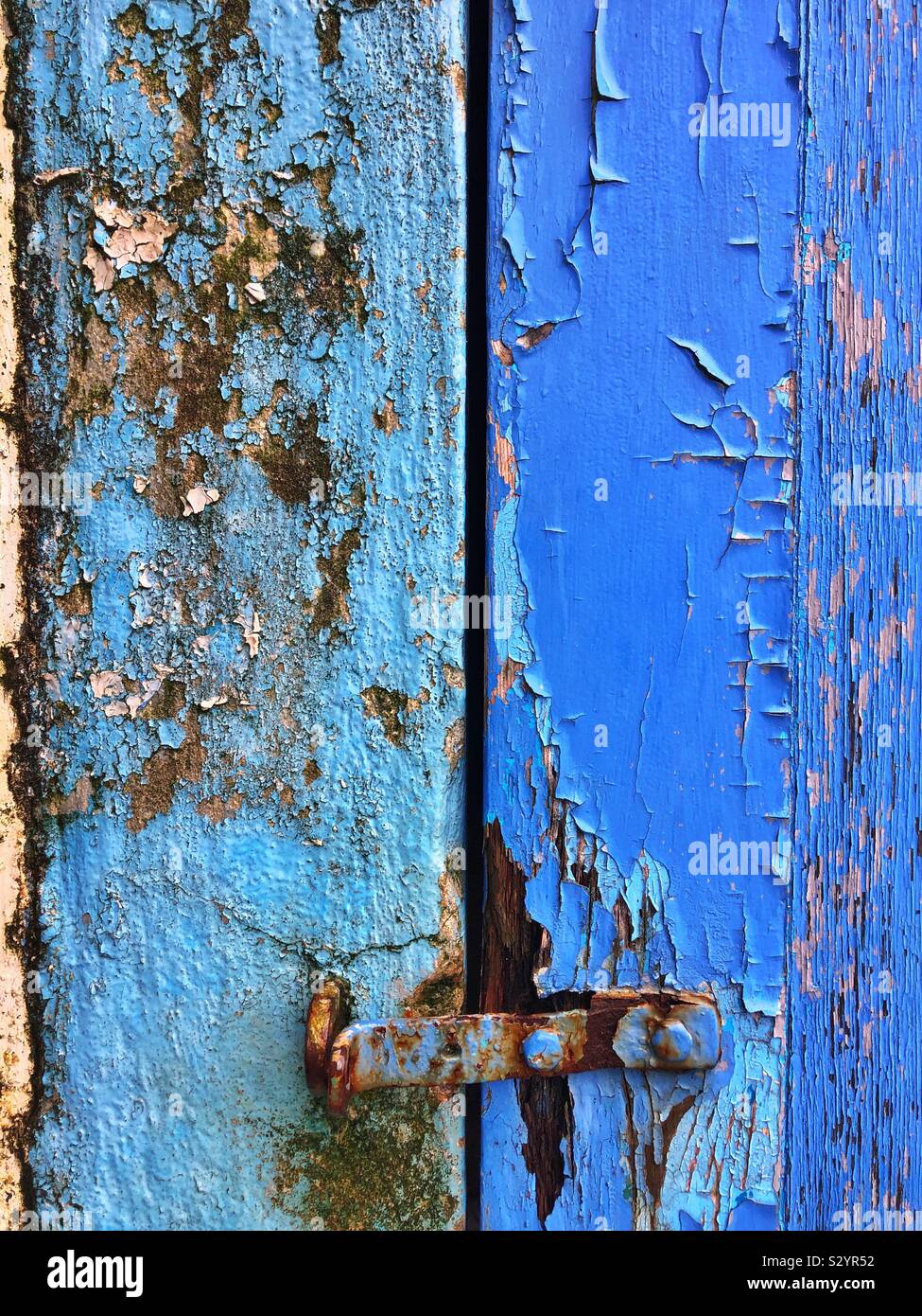 Latch on an old blue painted wooden door. Stock Photo