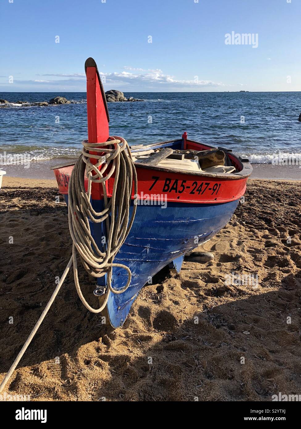 Traditional fishing boat moored on the beach in Calella de Palafrugell on Costa Brava in Spain. - Smartphone Captured Stock Image