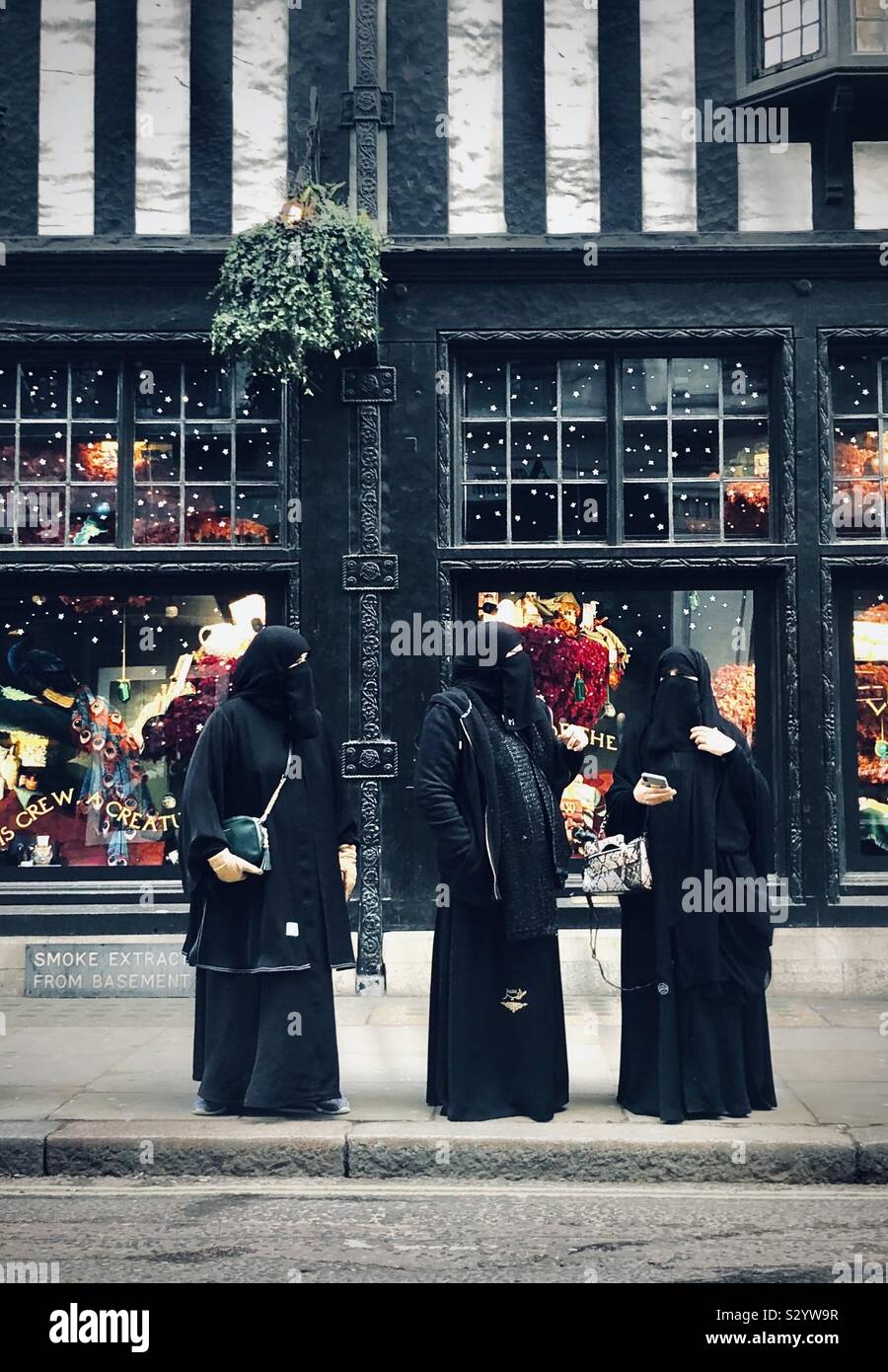 Three Muslim women standing outside libertys in london Stock Photo