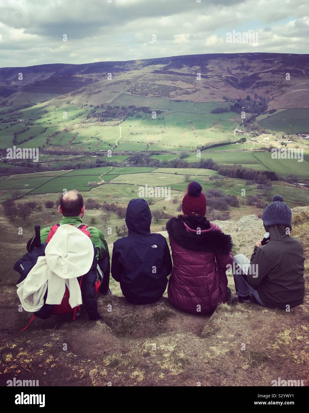 Hiking family holiday in the Peak District. Family of four chilling and enjoying the view after